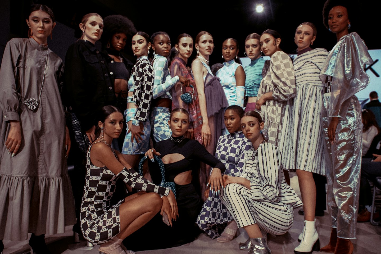Models wearing patterned contemporary fashion pose in a studio.
